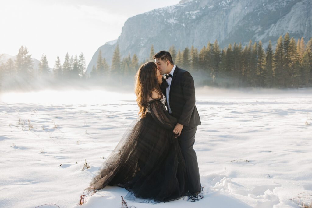 Couple holding hands in snowy Yosemite landscape