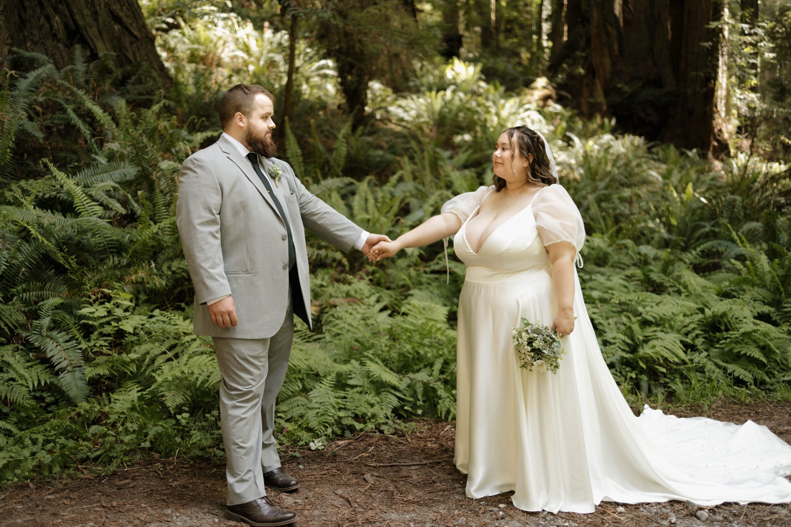 Couple holding hands in a forest elopement